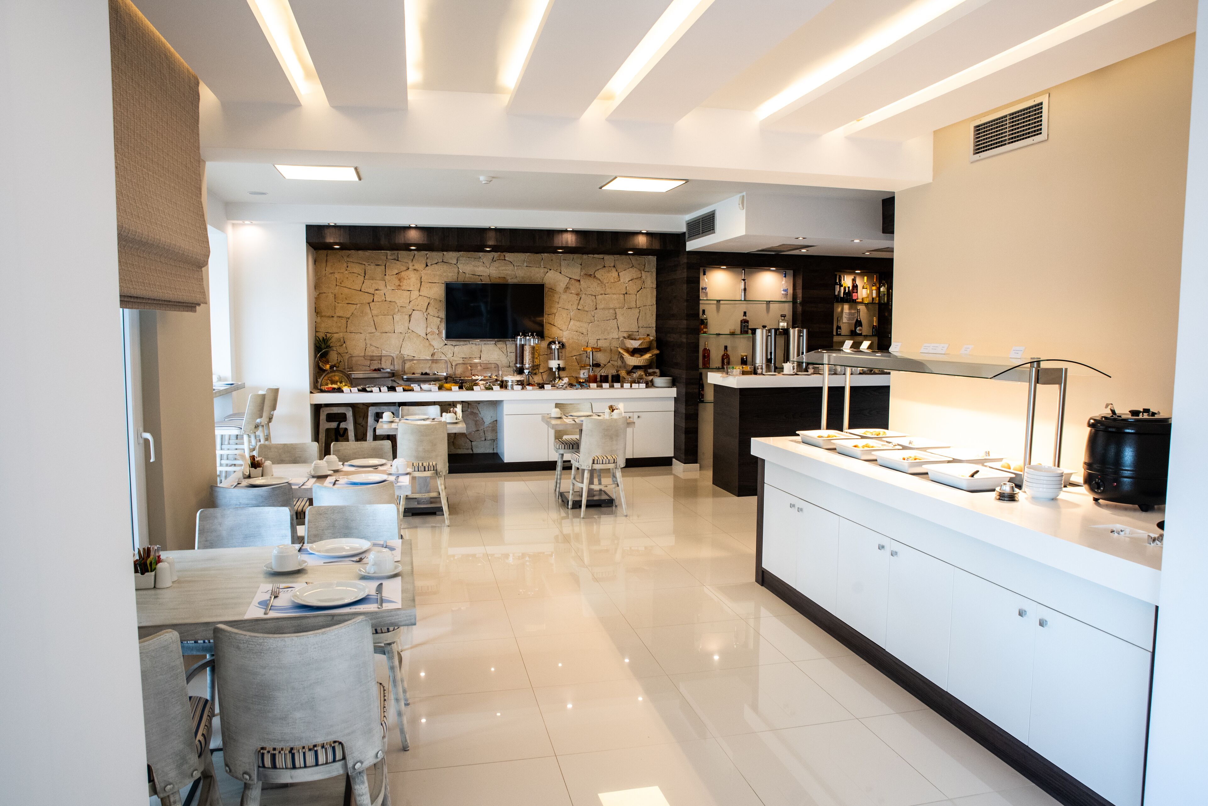 Una cocina moderna con protector de piedra, una isla central y una zona de bar.