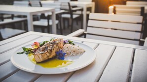 A plate of food on a white table with a sunset in the background. - Hampton Inn & Suites Richmond - Downtown (Richmond)