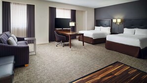 A hotel room with a bed, a desk, a chair, a TV, and a lamp. - Hampton Inn & Suites Richmond - Downtown (Richmond)