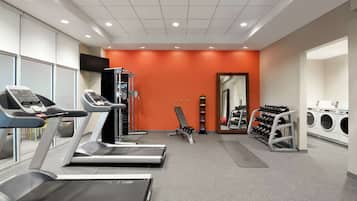 A gym with treadmills, weights, and a mirror.