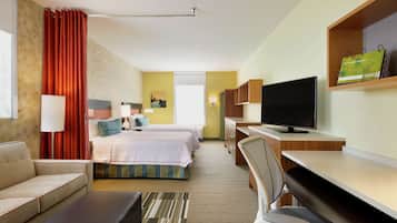 Une chambre d’hôtel équipée d’un lit, d’un bureau, d’une télévision, d’un canapé et d’une chaise.
