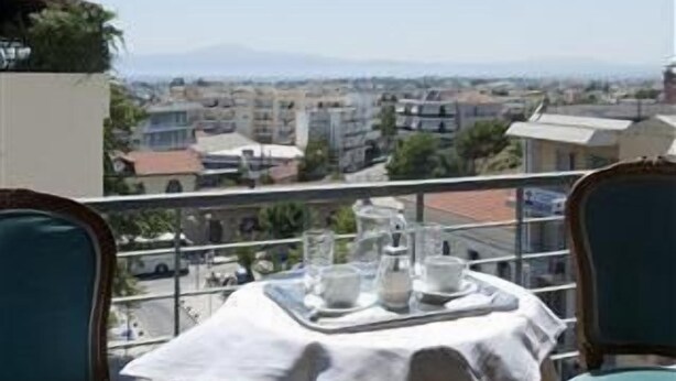Un balcón con una mesa para dos, con vistas a un paisaje urbano.