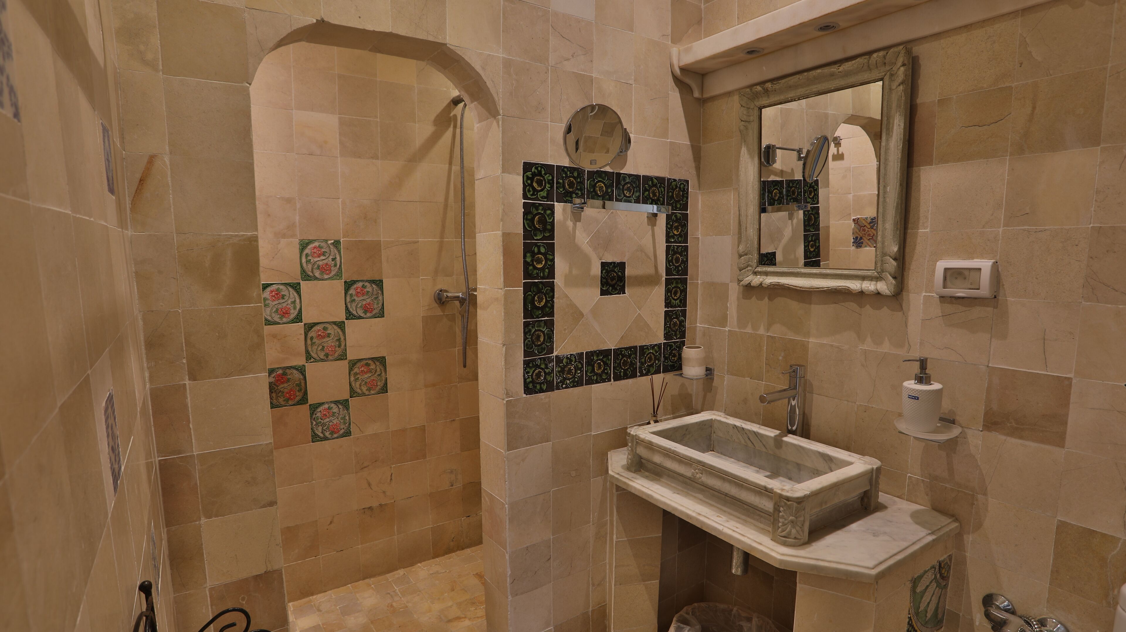 A bathroom with a sink, mirror, and shower.
