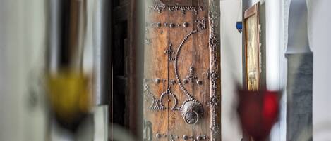 Una puerta de madera rústica con remaches metálicos y un picaporte de latón.