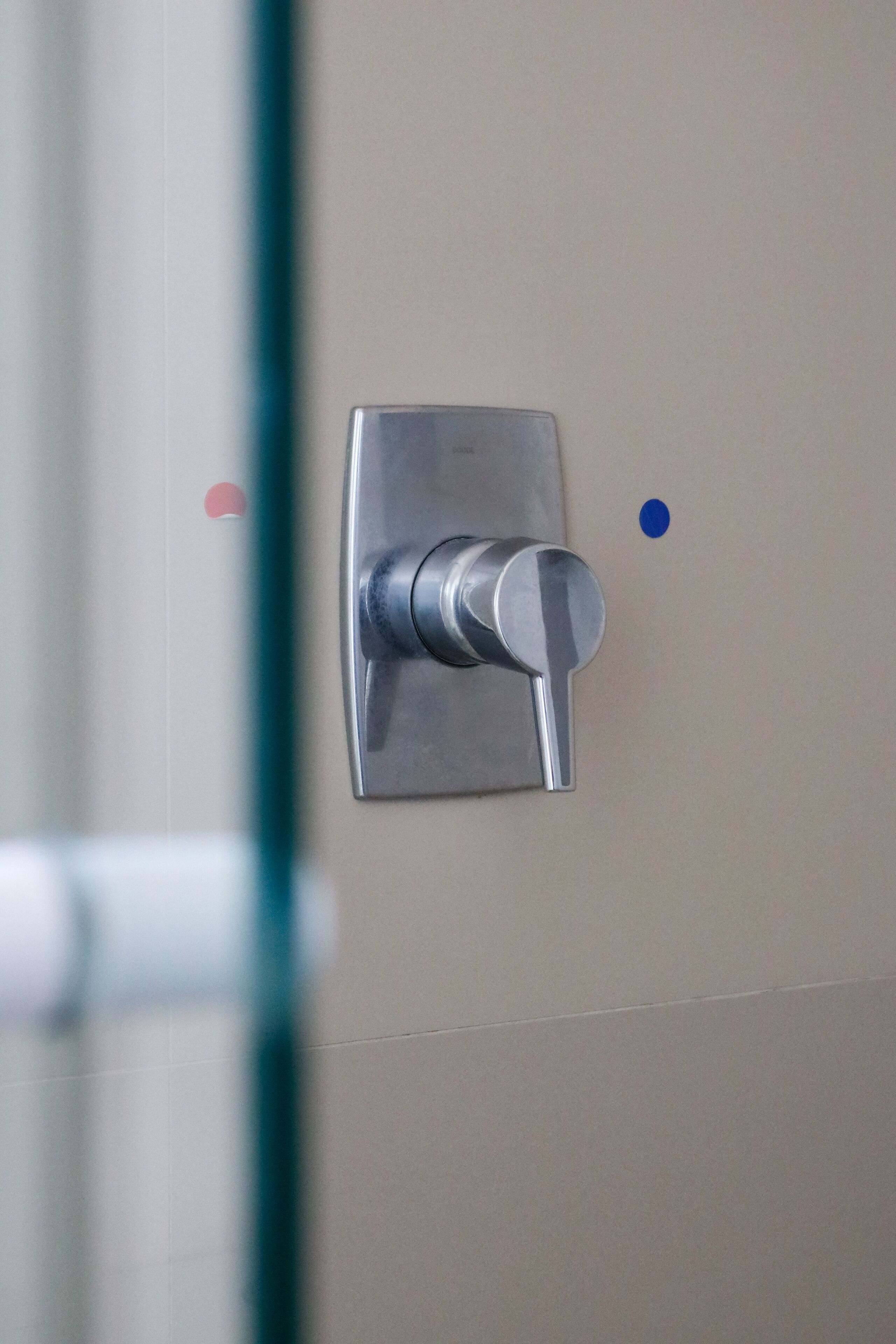 A metallic door handle on a beige wall.