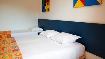 A hotel room with a large bed, a smaller bed, and a colorful artwork on the wall.