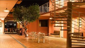An outdoor area with a staircase, chairs, and a tree. - Hotel Açoriano (Penha)