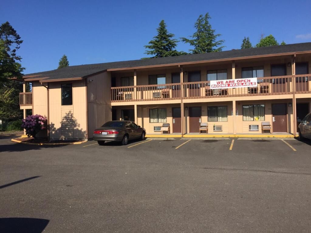 A motel with a signboard stating "WE ARE OPEN ROOMS AVAILABLE".