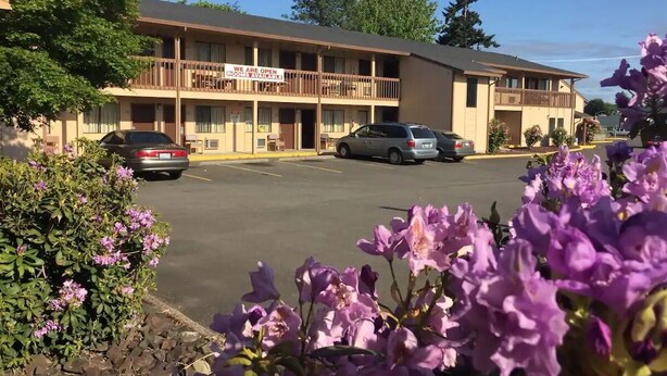 Un motel con un cartel que indica habitaciones disponibles.