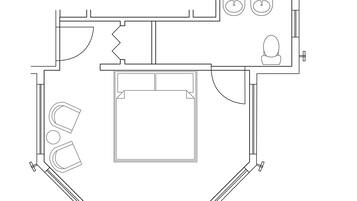 A floor plan of a hotel room with a bed, a bathroom, a kitchenette, and a seating area.