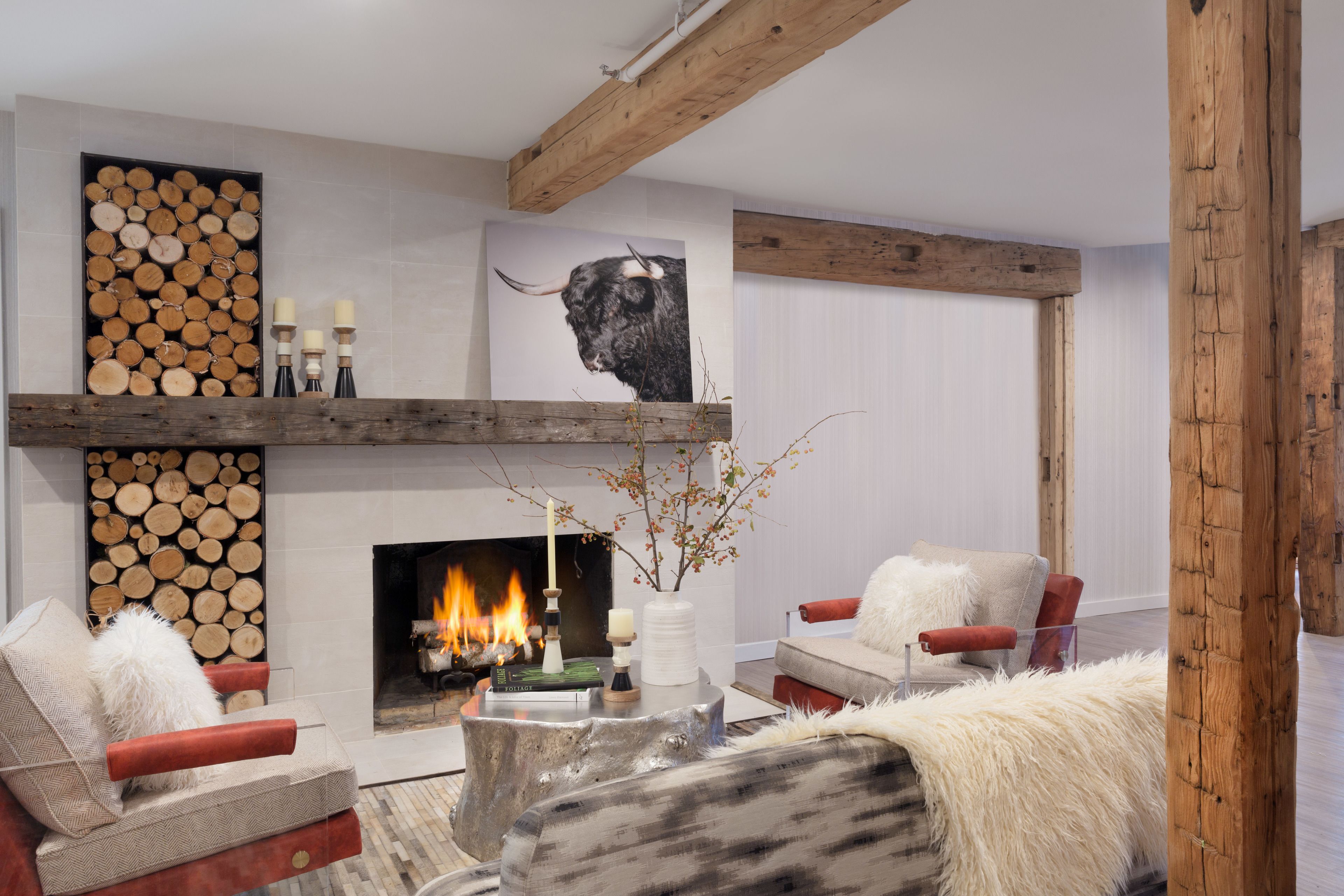 A modern living room with a fireplace, wooden beams, and comfortable seating.