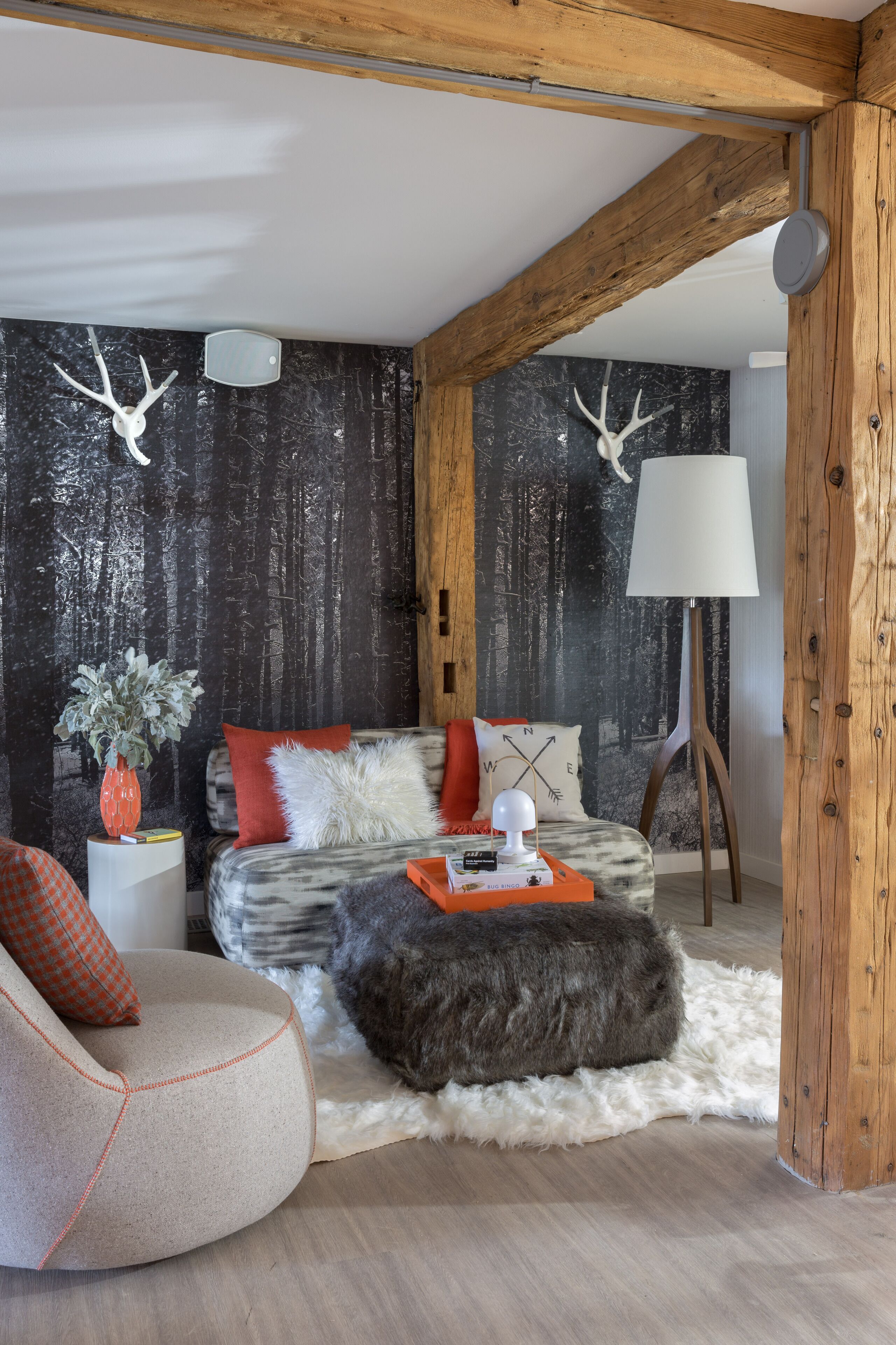A cozy living room with a sofa, ottoman, and a lamp.