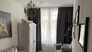 A modern living room with a sofa, a coffee table, a desk with a chair, and a cabinet. - Hotel Jägerhof Kettwig (Essen)