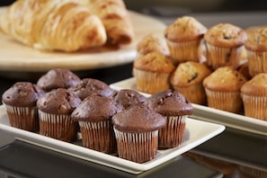 A tray of chocolate muffins and a croissant on a white plate. - DoubleTree by Hilton Coventry Building Society Arena (Coventry)