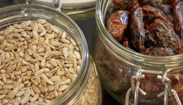 Two glass jars filled with almonds and dates. - DoubleTree by Hilton Coventry Building Society Arena (Coventry)