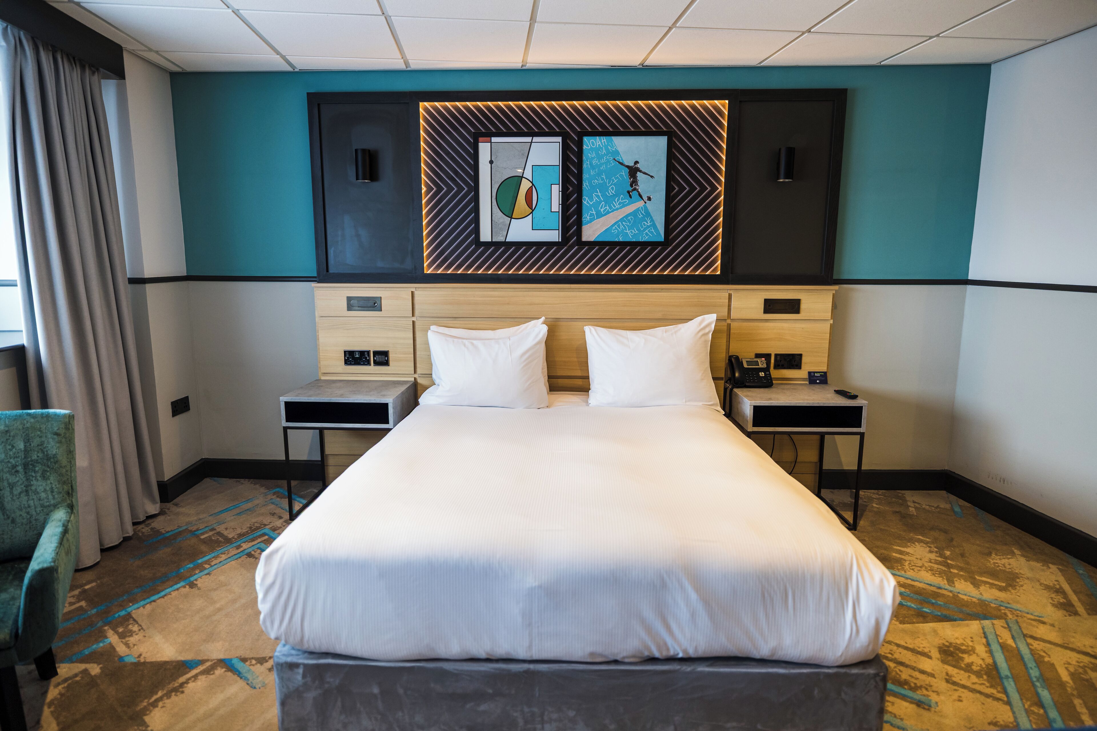 A hotel room with a large bed, two bedside tables, a desk, and a chair.