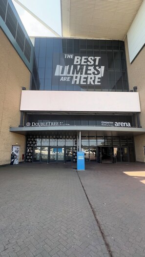 A modern building with a large glass facade and a sign that reads "THE BEST WILSES ARE HERE".