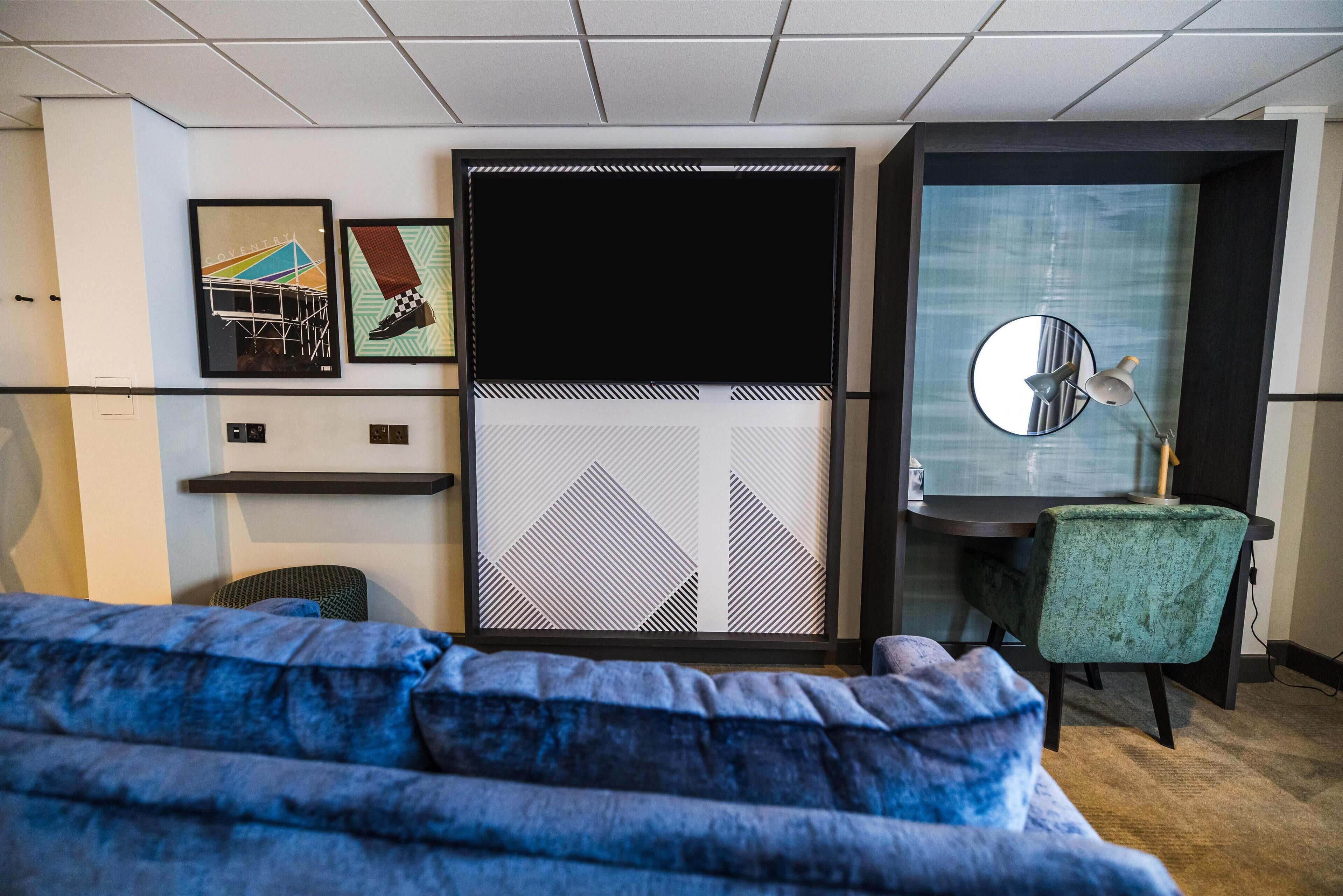 deluxe room, 1 queen bed | living area | flat-screen tv