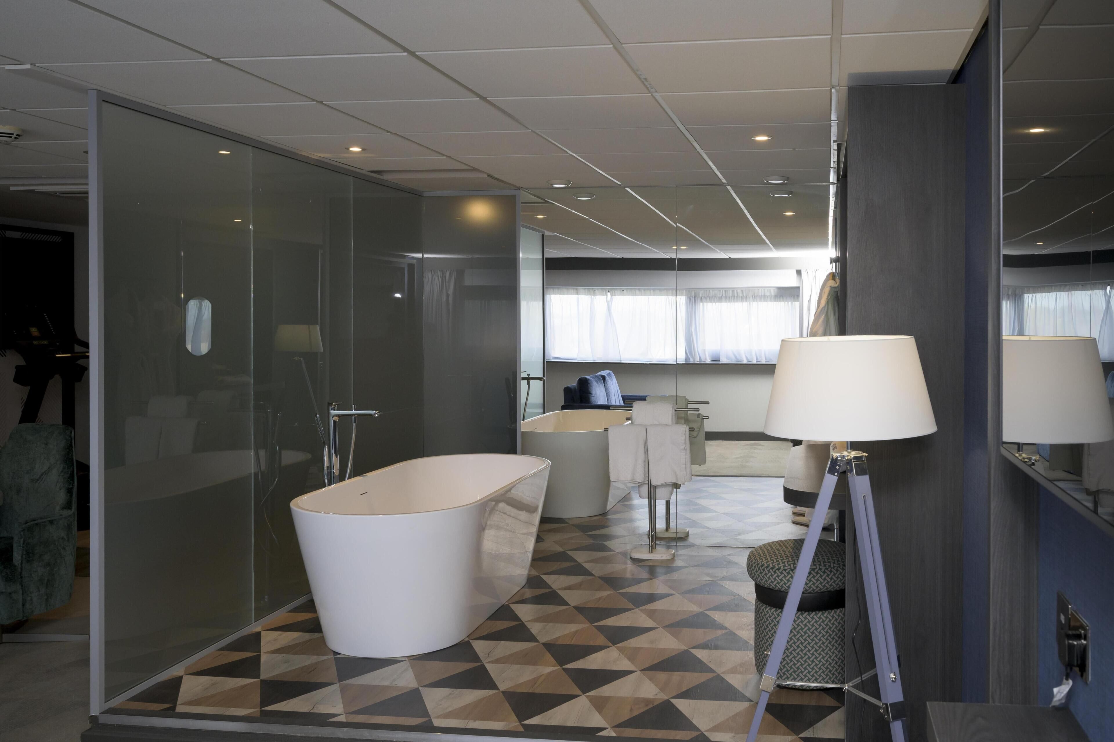 A modern bathroom with a freestanding bathtub, a glass-enclosed shower, and a large mirror.