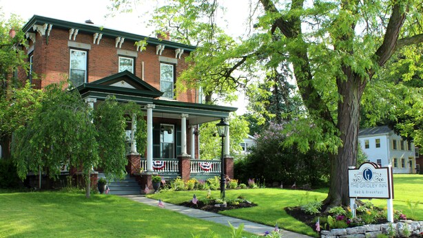 Un bâtiment traditionnel en briques, doté d’un porche vert et d’une enseigne indiquant « The Gridley Inn Bed & Breakfast ».