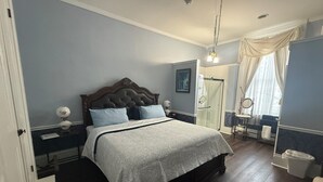 Une chambre à coucher bien aménagée, avec un grand lit, des tables de chevet, une coiffeuse avec un miroir et un dressing.