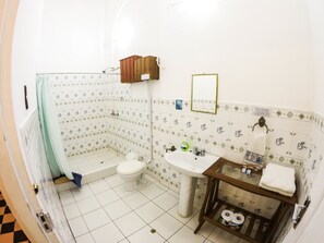 A bathroom with a toilet, sink, and shower area. - Apart Hotel Casa Morey (Iquitos)