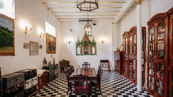 Una habitación con piso a cuadros, muebles de madera y un candelabro.