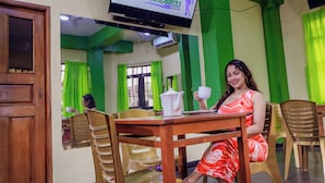Una habitación con una televisión mostrando 'Hospedaje Las Amazonas' y una mesa con un hervidor blanco y una taza.