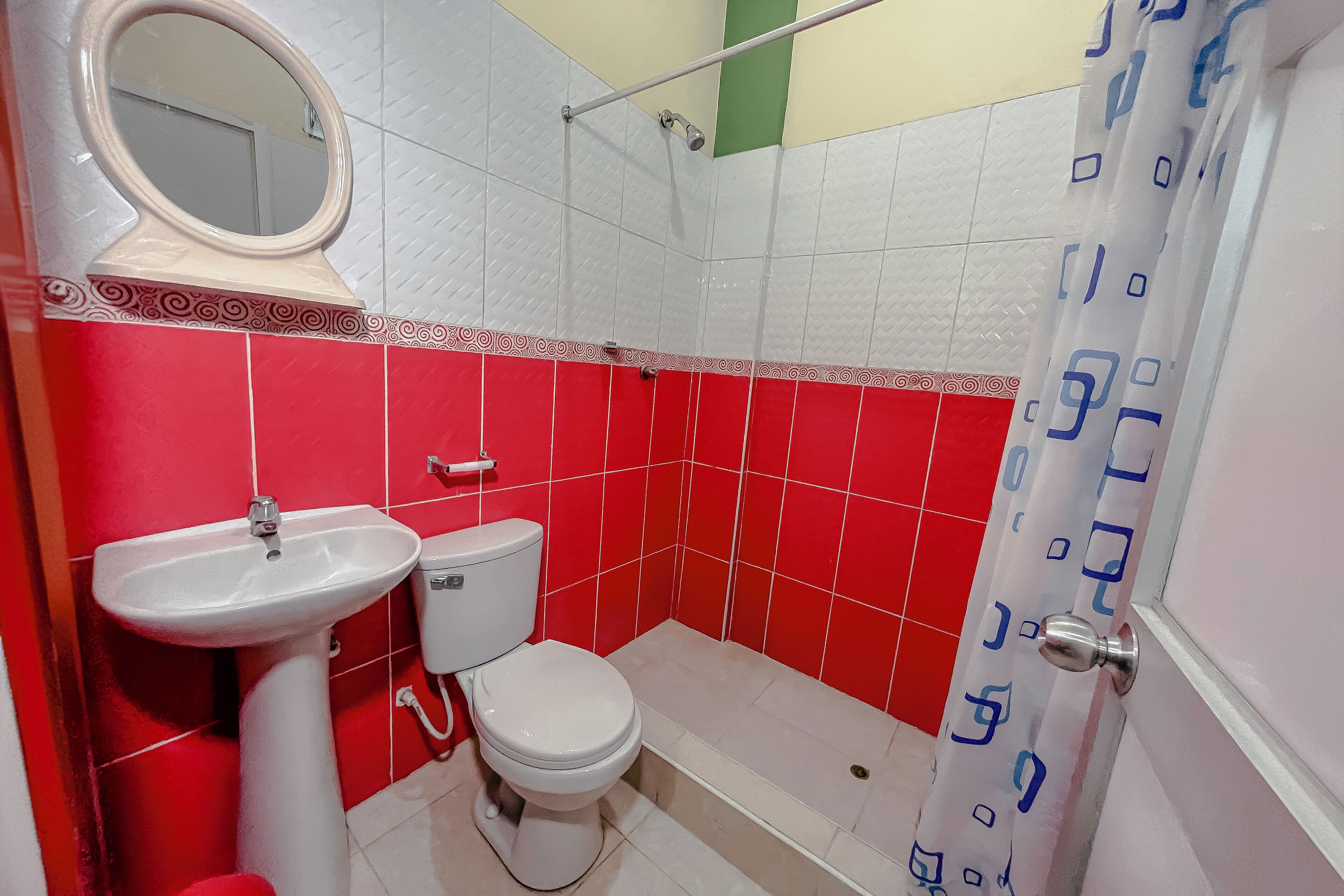 A bathroom with a white sink, toilet, and a shower area.