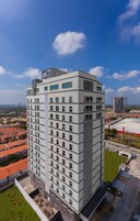 Un moderno edificio de hotel con varios pisos, ventanas amplias y un llamativo letrero que dice 'hotel' en la parte superior.