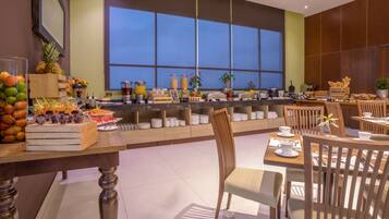 A breakfast buffet with various fruits, cereals, and beverages.