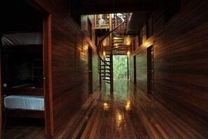 A wooden interior with a spiral staircase leading to a balcony.