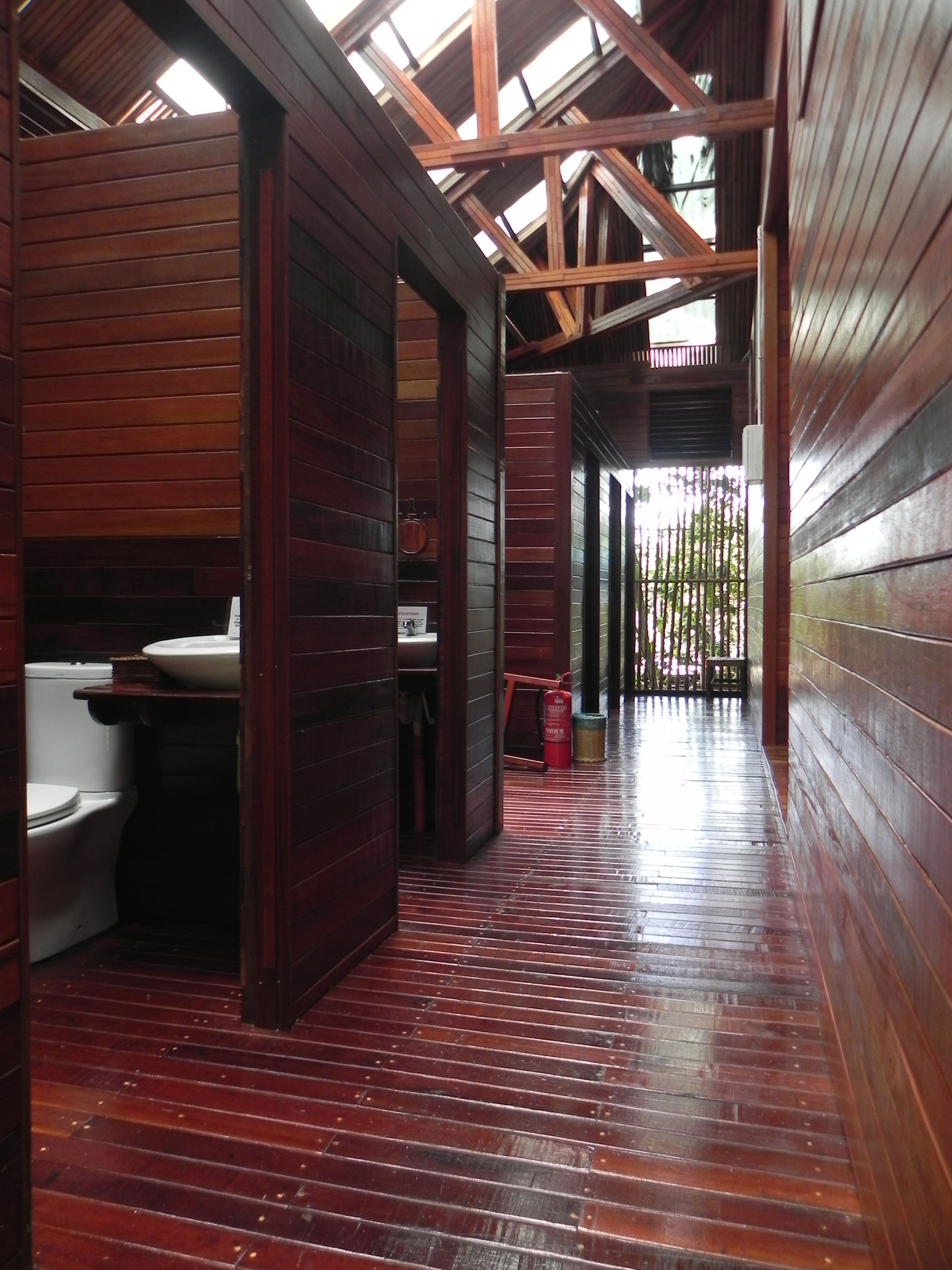 Ein Zimmer mit Holzboden, Toilette und Waschbecken, alles aus Holz.