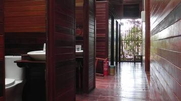 Ein Zimmer mit Holzboden, Toilette und Waschbecken, alles aus Holz.