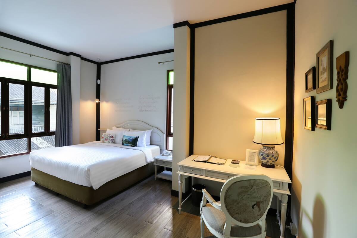 Une chambre d’hôtel avec un lit, un bureau, une chaise et une vue sur l’extérieur.