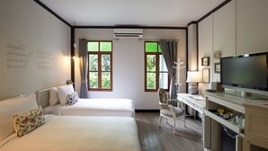 A hotel room with two beds, a desk with a television, and a chair. - The Raweekanlaya Hotel Bangkok (Bangkok)