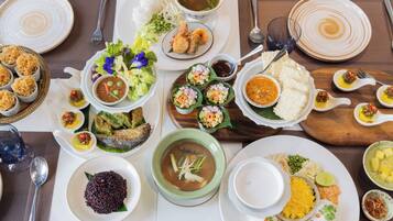 Une table garnie de différents plats, notamment du riz, de la soupe et de la viande.