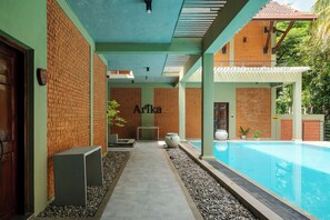 Una piscina al aire libre, sillones reclinables de piscina