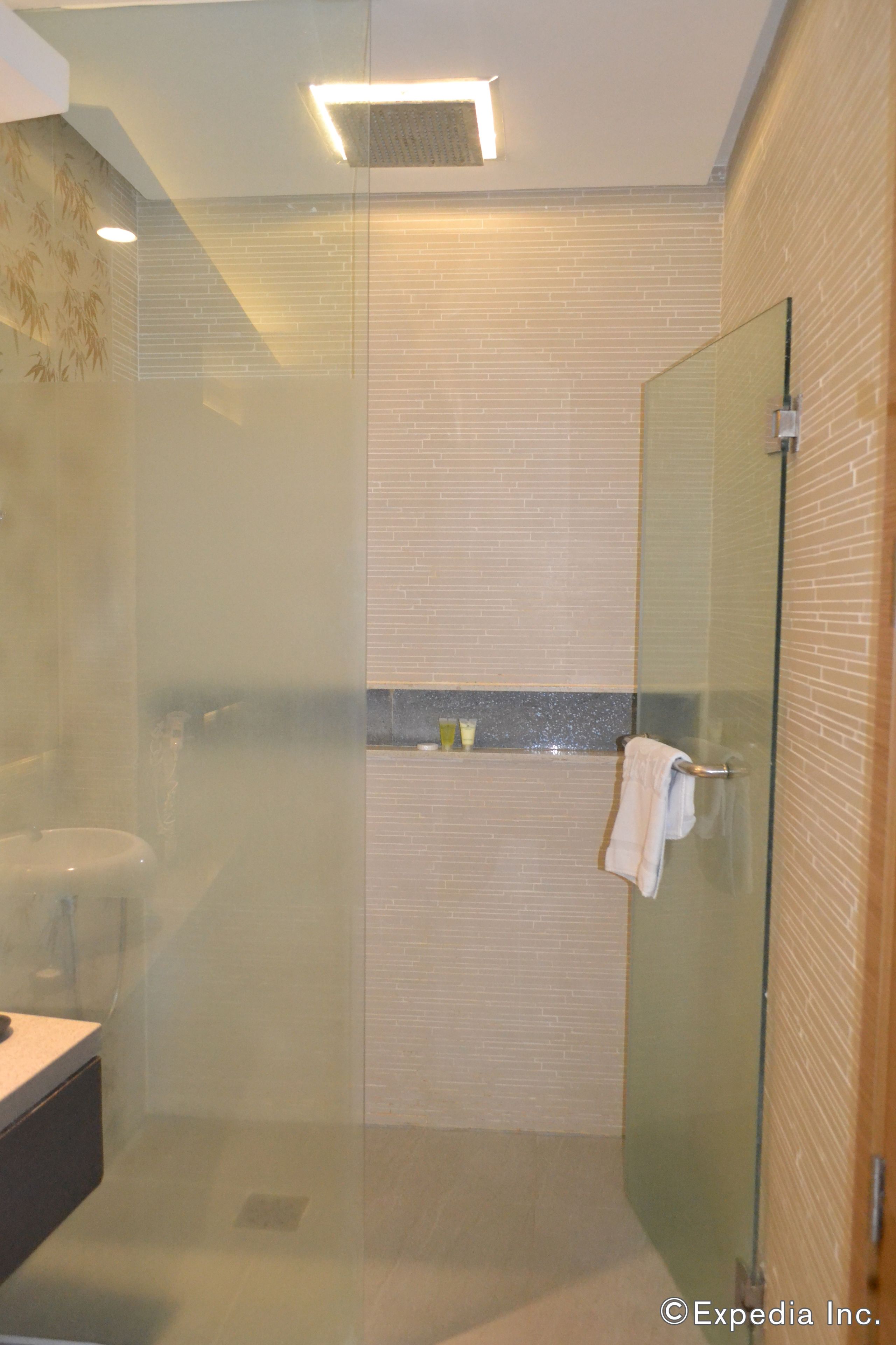 A modern bathroom with a glass-enclosed shower, a toilet, and a sink.