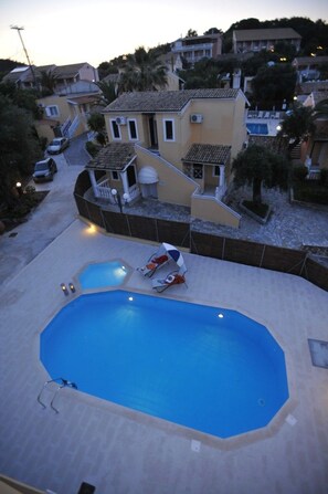 A residential area with a swimming pool, a small deck, and a staircase leading to a house. - Saint Spiridon Hotel (Corfu)