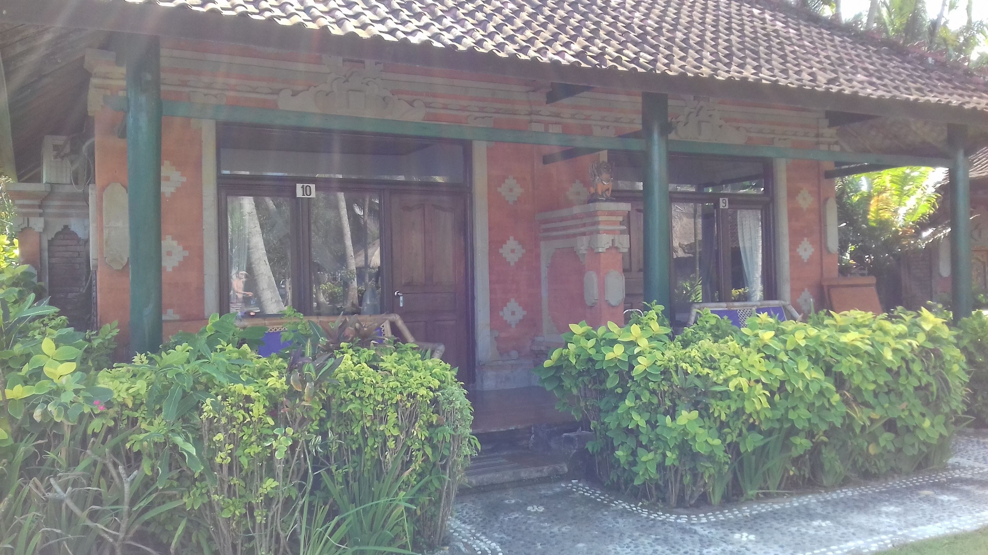 A traditional building with a tiled roof, numbered doors, and a covered entrance area.