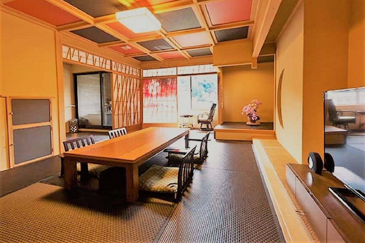 A traditional Japanese-style room with tatami flooring, a low table, and sliding doors.
