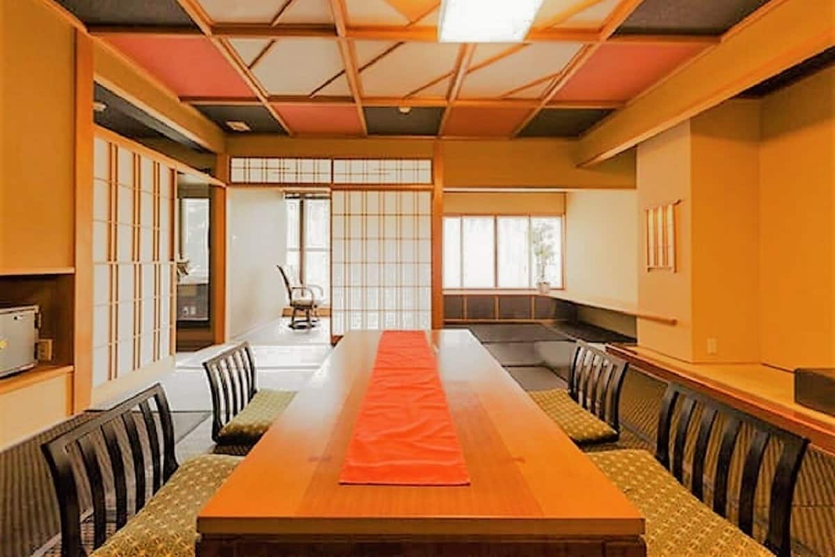 A traditional Japanese room with tatami mats, a low table, and sliding doors.
