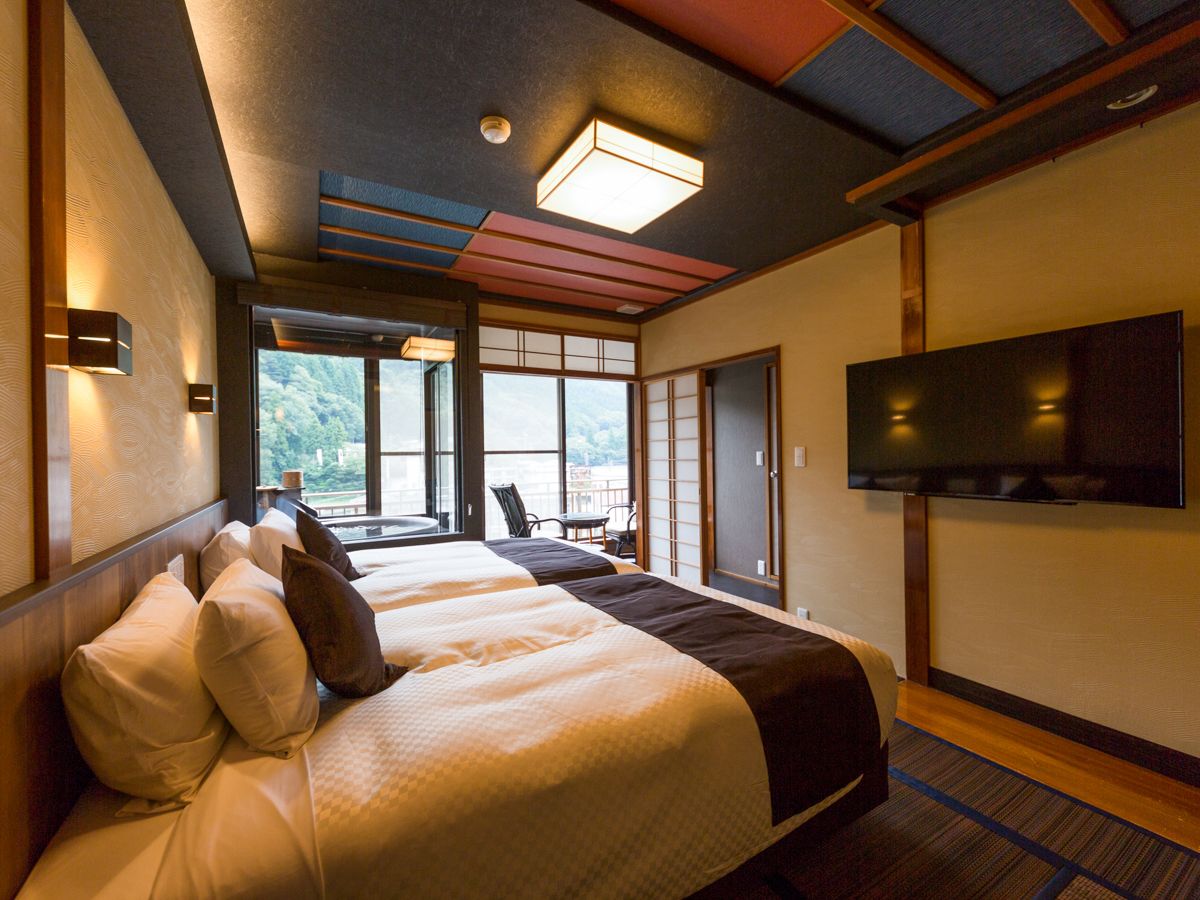 A hotel room with a large bed, a TV, and a view of the outdoors.