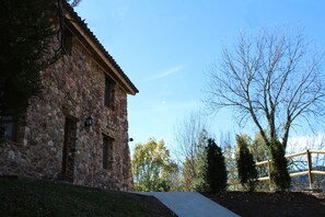 Situated on a serene grassy area, this traditional building features a sloped roof and a small window.