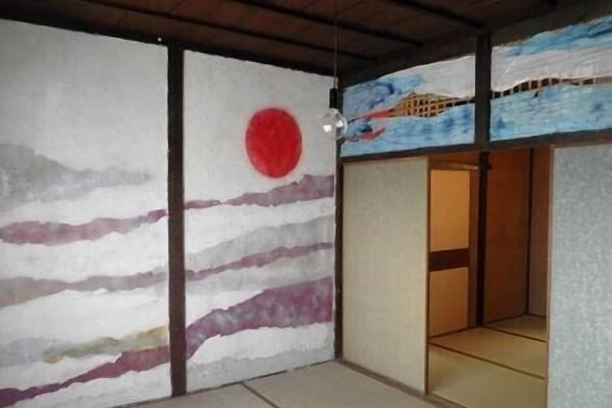 Een traditionele Japanse kamer met tatami vloeren, shoji schermen en een rode cirkel op de muur.