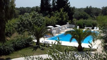 Alberca al aire libre, sombrillas en la alberca y camastros