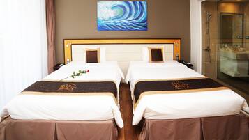 A hotel room with two beds, a large painting on the wall, and a glass shower enclosure.