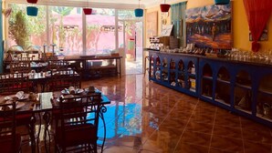 A restaurant with a bar area, tiled floor, and hanging pendant lights. - Malabata Guest House (Tangier)