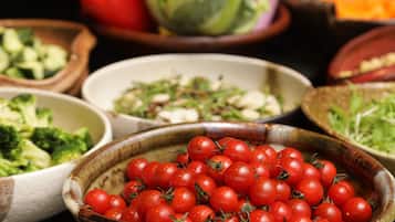 A variety of fresh vegetables in bowls, including tomatoes, broccoli, and lettuce.